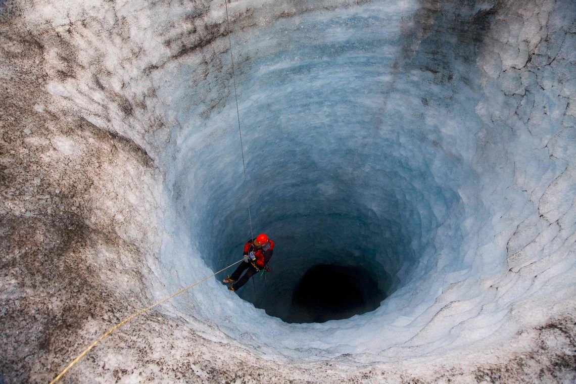 Descending into a deep hole in Solheimajokull in the southern part of Iceland